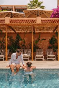 勒·雷约尔·卡纳德尔·苏尔露台巴里酒店的坐在游泳池里的男人和女人