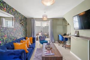 纽尼顿Stunning 3 bed Abode in Nuneaton- Sleeps 7的客厅配有蓝色沙发和橙色枕头。