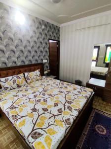 斋浦尔Sukh Sagar Hotel的一间卧室配有一张黄色和白色毯子的床