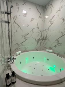 马德里Apartamentos Aguacate的带浴缸的浴室和大理石墙壁