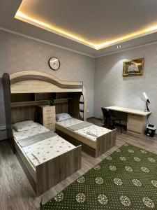 杜尚别Ultra Hostel的客房设有两张床、一张桌子和一张书桌。