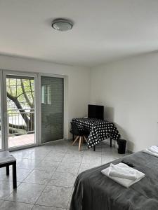 美因河畔法兰克福Pension Seckbach的一间卧室配有一张床、一张桌子和一个窗户。