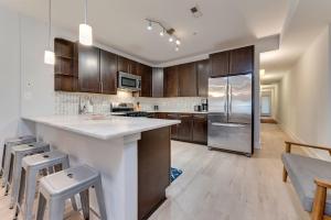 华盛顿Luxe Townhouse Flat in Hip Neighborhood, Near Metro的厨房配有木制橱柜和不锈钢冰箱。