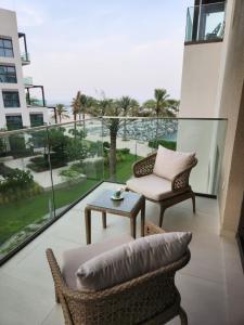 富查伊拉Address Beach Resort Fujairah - 2 bedroom apartment的阳台配有桌椅,享有海景。