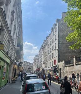 巴黎Charmant appartement sacré cœur avec parking gratuit的城市一侧有车辆停放的街道
