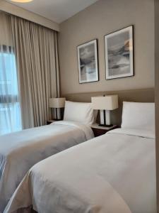 富查伊拉Address Beach Resort Fujairah - 2 bedroom apartment的酒店客房设有两张床和窗户。