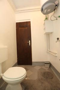 大戈里察Maple place的一间带卫生间和棕色门的浴室