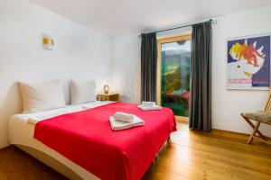 基茨比厄尔Chalet Mora-lodge by Alpine Host Helpers的一间卧室配有红色的床和红色毯子
