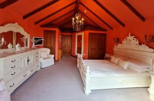 埃尔默顿Barley View的一间设有两张床和吊灯的大卧室