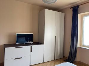 Settimo VittoneCivicocentouno的卧室配有白色橱柜和电脑