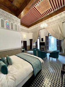 非斯Le Grand Alcazar - Riad的卧室配有一张床和一张桌子及椅子