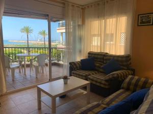 塞古德卡拉斐Apartamento Primera Línea de Playa Port-Segur的带沙发和桌子的客厅以及阳台。