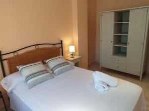 塞古德卡拉斐Apartamento Primera Línea de Playa Port-Segur的卧室配有白色的床和2个枕头