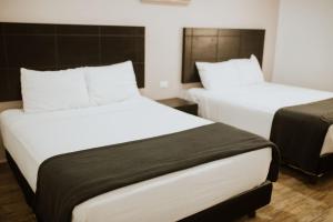 蒙克洛瓦Hotel Capital Frontera的白色和黑色客房的两张床