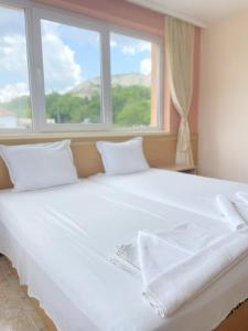 巴尔奇克Family Hotel Morska Zvezda的一张白色大床,配有白色床单和窗户