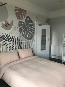 尚克林圣莱昂纳茨旅馆的卧室配有白色床,墙上有叶子