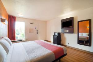 奥古斯塔Motel 6 - Augusta, GA的酒店客房设有一张床和墙上的电视