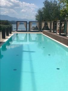 沃尔特湖畔佩莎赫Apartment Lake`s的享有水景的大型蓝色游泳池