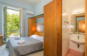 维亚雷焦Hotel Villa Benvenuti的一间卧室配有一张床,浴室设有水槽