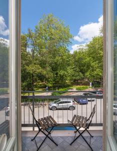 维亚雷焦Hotel Villa Benvenuti的阳台配有两把椅子,享有停车场的景致。
