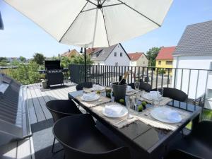 纽伦堡M-Style 04 Apartment mit Balkon und Gasgrill, 24h Self-Check-In, Free Parking, Netflix的阳台的桌子和雨伞