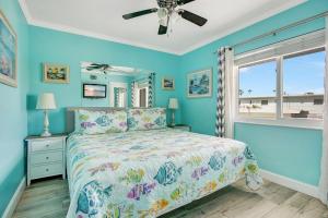 克利尔沃特Five Palms Vacation Rentals- Daily - Weekly - Monthly的一间卧室配有一张蓝色墙壁的床和一扇窗户