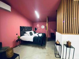 波尔多La Litchi Le 50 Suites and Spa centre ville的卧室配有一张粉红色墙壁上的床铺
