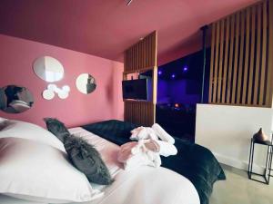波尔多La Litchi Le 50 Suites and Spa centre ville的一间卧室设有两张床和粉红色的墙壁