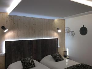 图勒LE PANORAMA et son SPA的一间卧室设有两张床和木墙