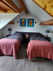奈弗达尔Bij Noetsele的阁楼卧室设有两张床,铺有木地板。