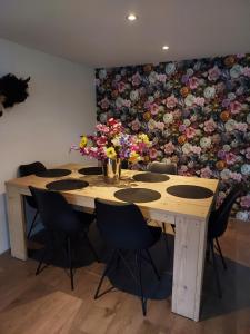奈弗达尔Bij Noetsele的墙上挂着带椅子和鲜花的木桌