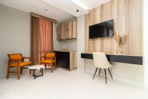 乌尔齐尼Trio Resort的一间带椅子和桌子的房间以及一台电视