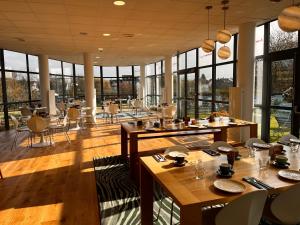 讷伊-普莱桑斯马恩博尔德纳伊住宅酒店的用餐室设有桌椅和窗户。