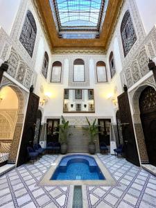 非斯Le Grand Alcazar - Riad的一座带天花板的建筑中的室内游泳池
