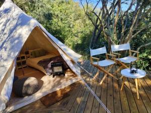 斯韦伦丹Gaia Double bell tent的帐篷,甲板上配有一张床和两把椅子