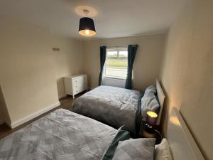 邓多克The Moorlands的一间小卧室,配有两张床和窗户
