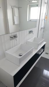 阿威罗皇室酒店的白色的浴室设有两个盥洗盆和镜子
