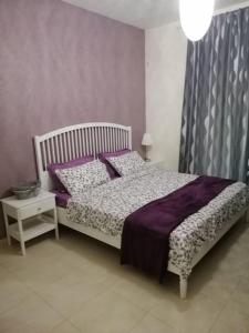 索瓦马Dead Sea Jordan Sea View Samarah Resort Traveler Award 2024 winner的一间卧室配有一张带紫色床单和枕头的床。