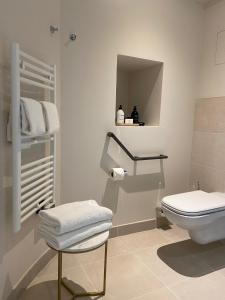 翁弗勒尔L'Invitation au Voyage Hôtel- Espace Bien-être - Bar Lounge的一间带卫生间的浴室和一个带毛巾的架子