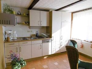 RambinRuegen_Fewo 23的厨房配有白色橱柜和桌椅