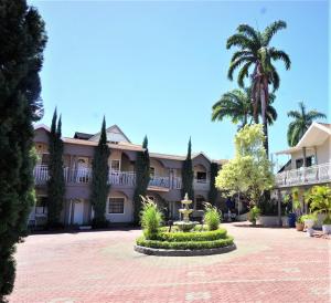 西班牙港The Chancellor Hotel的一座棕榈树和庭院的建筑