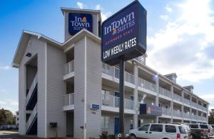 夏洛特Intown Suites Extended Stay Charlotte NC - North Tryon的前面有标志的大建筑