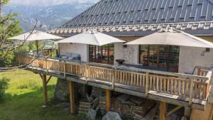 巴斯洛内特Superbe ferme rénovée en chalet de luxe en PLEINE NATURE的大楼前带遮阳伞的木甲板