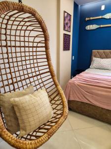 瓜拉派瑞GUARALOFT MAJORCA GUARAPARI的卧室内的藤椅和床