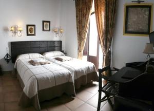 拉普埃夫拉德洛辛凡特斯La Posada Del Infante的一间卧室配有一张床、一张书桌和一个窗户。
