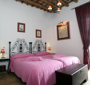 拉普埃夫拉德洛辛凡特斯La Posada Del Infante的一间卧室配有一张带粉红色床罩的床
