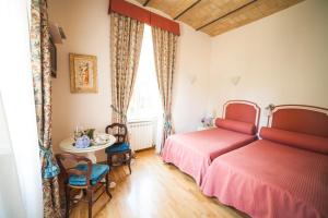 罗马帕格尼尼住宿加早餐旅馆的一间卧室设有两张床、一张桌子和一个窗口