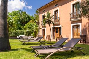 BolullaBoutique Hotel Finca el Tossal - Adults Only的一排躺椅在房子前面