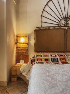 马萨夫拉Novecento Room and Breakfast Puglia的一间卧室配有一张带木制床头板的床