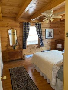 New HopeBeautiful Log Home, Lake side.的小木屋内的卧室配有1张床和镜子